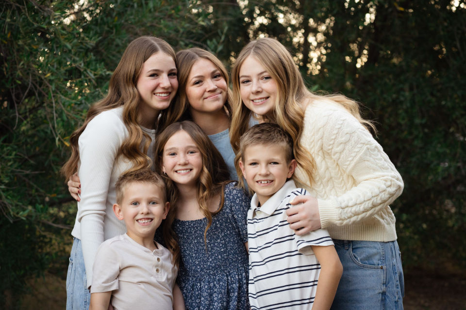 Four sisters gather for a close portrait in the trees.