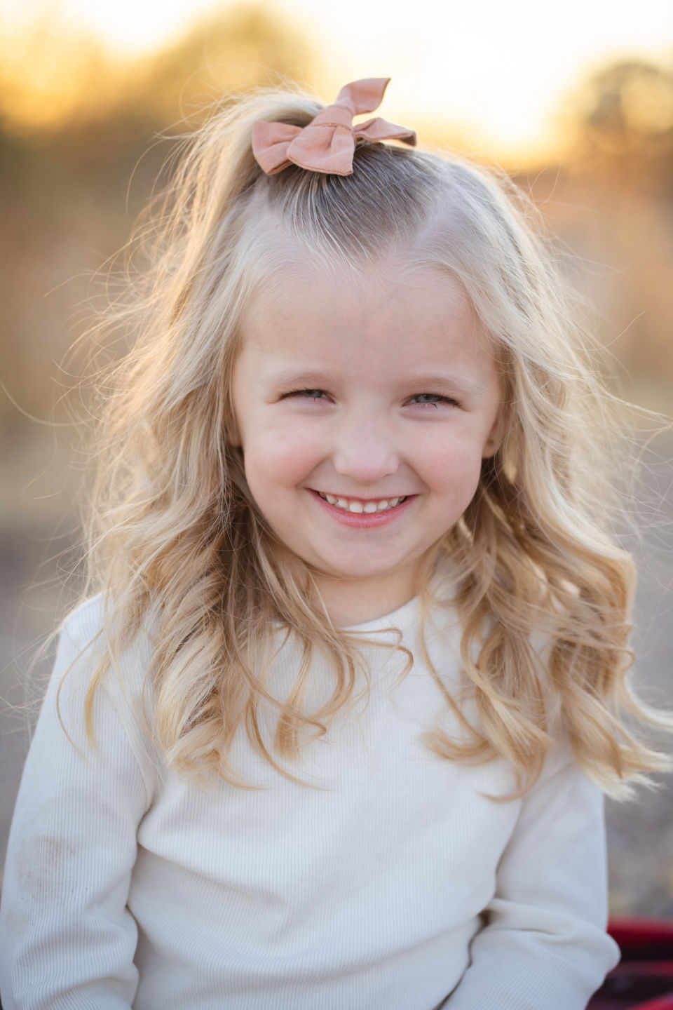 Smiling young girl with a bow in her hair.
