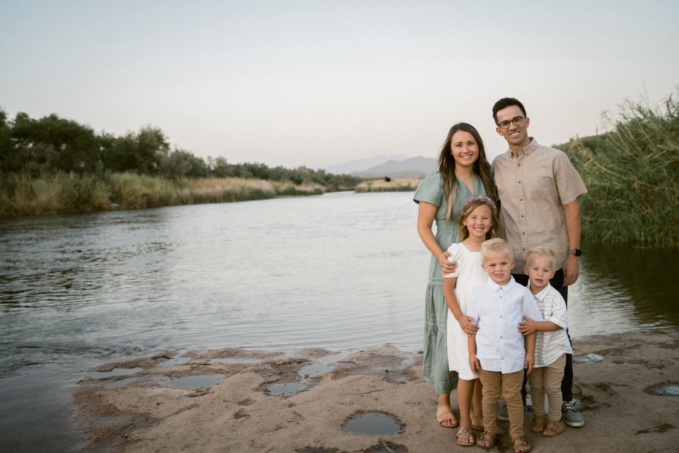 Willett family together beside the river at dusk.