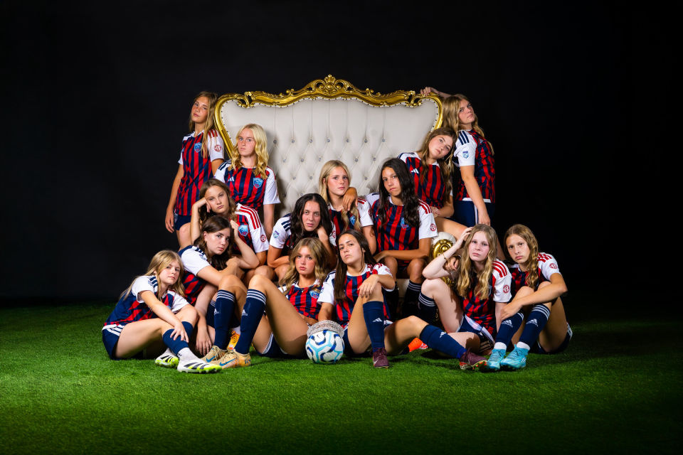 Soccer teammates posed around a white and gold throne with serious expressions.