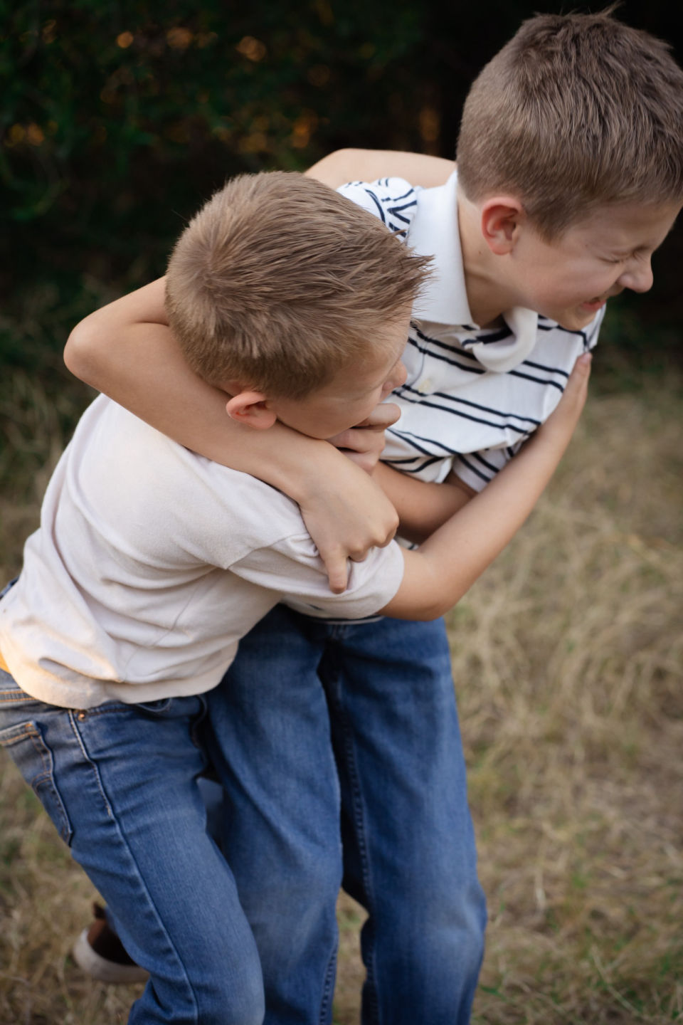 Two brothers lean into a playful hug.