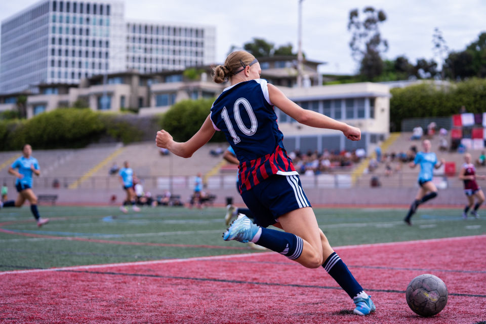 Soccer player wearing number 10 winds up for a kick during a daytime game in La Jolla.