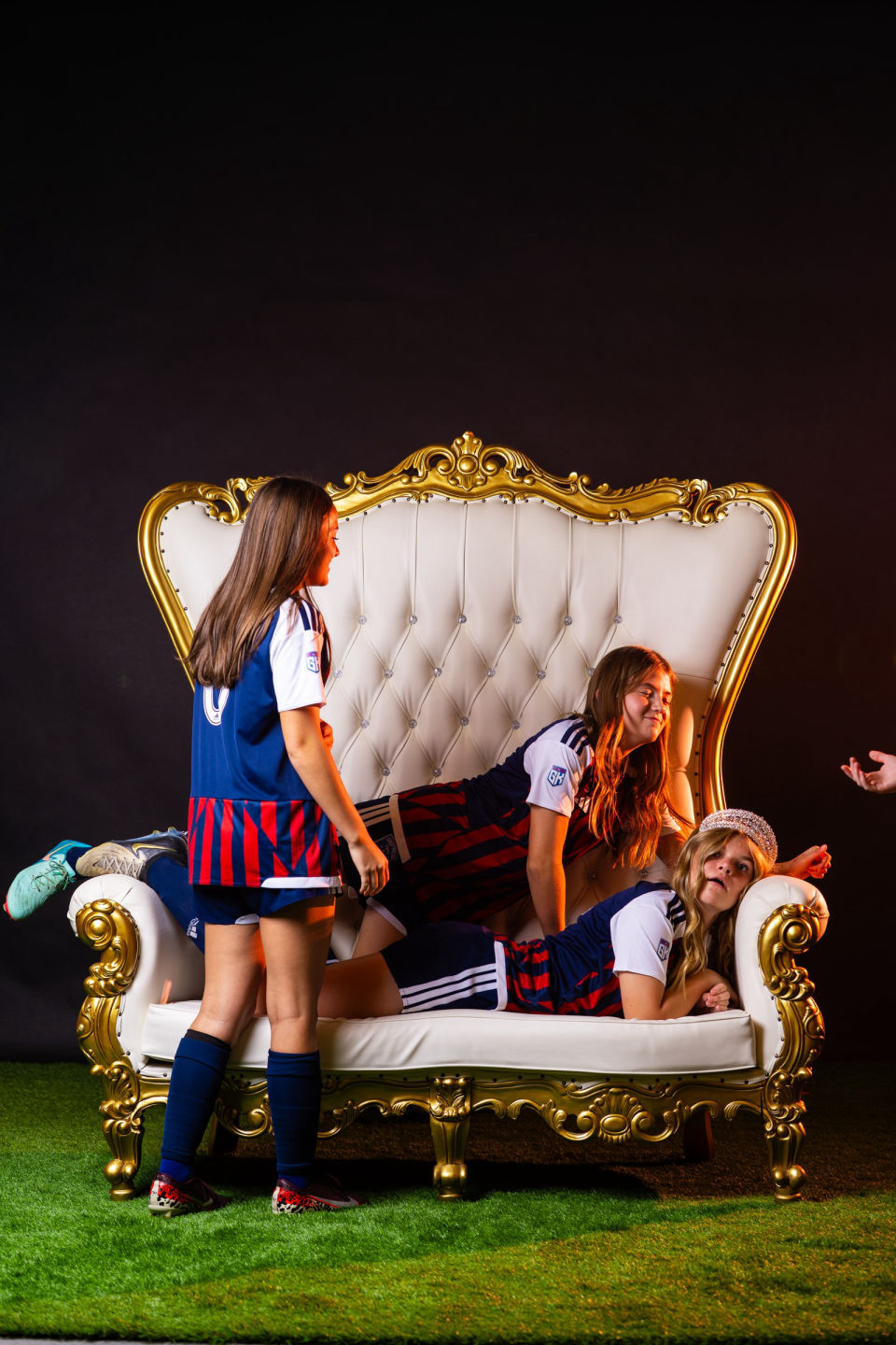 Two teammates strike playful poses beside the white-and-gold throne.