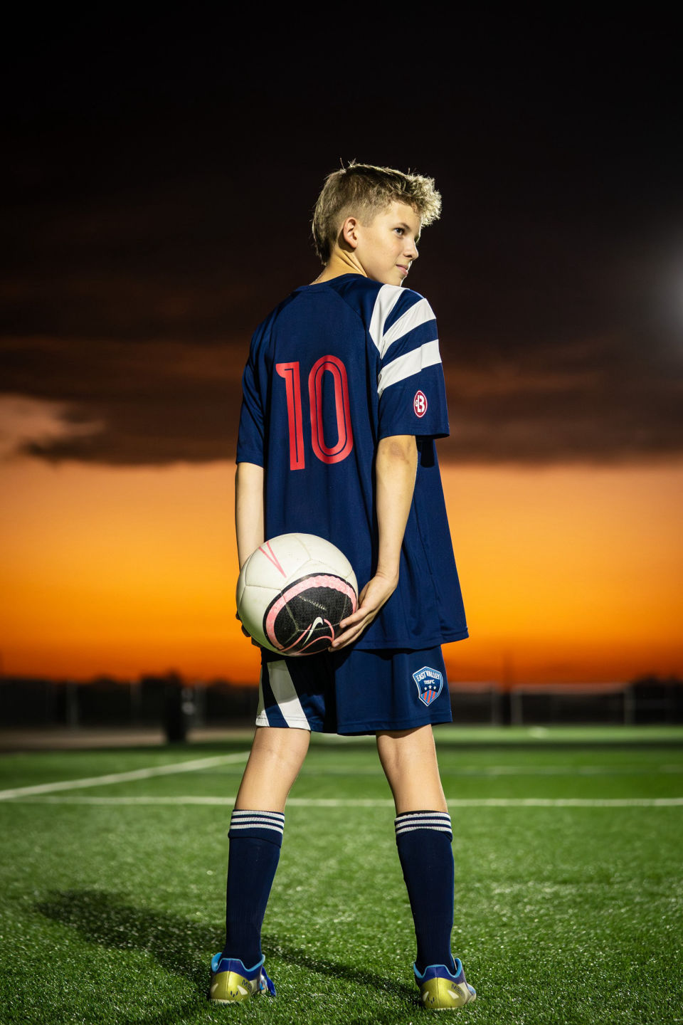 Kaysen shows his number 10 jersey while holding a soccer ball behind his back.